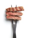 Slices of beef steak on meat fork on white background from above Royalty Free Stock Photo