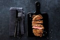 Slices beef Steak Ribeye on a black cutting board