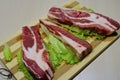 Slices of beef on a wooden board on the table.