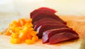 Slices of boiled red beat and carrots on a wooden board Royalty Free Stock Photo