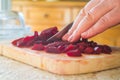 Slices of boiled red beat on a wooden board and a hand Royalty Free Stock Photo