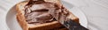 Slices of bread with chocolate hazelnut cream and knife on a wooden background panorama Royalty Free Stock Photo