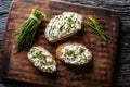 Slices of bread with a cottage cheese spread, freshly cut chives, and a bunch of chive aside placed on a dark brown Royalty Free Stock Photo