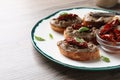 Slices of bread with delicious pate, sun dried tomatoes and basil on wooden table. Space for text Royalty Free Stock Photo