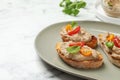 Slices of bread with delicious pate, tomatoes and basil on white marble table, closeup. Space for text Royalty Free Stock Photo