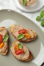 Slices of bread with delicious pate, tomatoes and basil on white marble table, flat lay Royalty Free Stock Photo