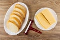Slices of bread in dish, cheese cutter, piece of cheese in plate on table. Top view