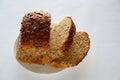 Slices of bread from several grains of sunflower and pumpkin and flax seeds in a white plate Royalty Free Stock Photo