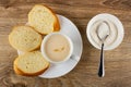 Slices of bread, white cup with fermented baked milk on plate, spoon in bowl with sugar on table. Top view Royalty Free Stock Photo