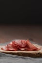 Slices of bresaola on olive serving board