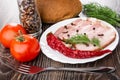 Slices of brisket, clove and black pepper, dill in plate, tomatoes, garlic, bread, red tomatoes, bottle of condiment, fork on