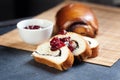 Slices of butter poppy roll, served with cherry jam. Black table, bamboo mat Royalty Free Stock Photo