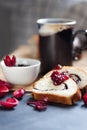 Slices of butter poppy roll, served with cherry jam and large ceramic cup with hot drink. Royalty Free Stock Photo