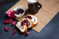 Slices of butter poppy roll, served with cherry jam and large ceramic cup with hot drink. Royalty Free Stock Photo