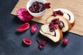 Slices of butter poppy roll, served with cherry jam lying on a black table. Royalty Free Stock Photo