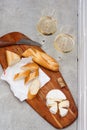 Slices of camembert cheese, baguette and two glasses of white wine on wooden board. White brick wall as background Royalty Free Stock Photo