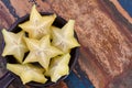 Slices of carambola fruit on black plate