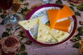 Slices of cheese on a plate with a glass of wine