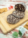 slices chocolate salami with biscuits on a cutting board with turkish delight and biscuits near