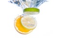 Slices of citrus fruit falling in water Royalty Free Stock Photo