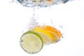 Slices of citrus fruit falling in water Royalty Free Stock Photo