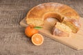 Slices of clementine cake with powdered sugar topping. Cake on a board with fresh clementines on wooden board Royalty Free Stock Photo