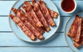 Crispy Bacon Strips on Blue Plates with Sauce Royalty Free Stock Photo