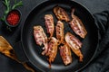 Slices of crispy hot fried cooked bacon. Farm organic meat. Black background. Top view Royalty Free Stock Photo