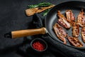 Slices of crispy hot fried cooked bacon. Farm organic meat. Black background. Top view Royalty Free Stock Photo