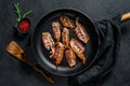 Slices of crispy hot fried cooked bacon. Farm organic meat. Black background. Top view Royalty Free Stock Photo