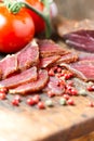 Slices of cured meet on wooden table angled view Royalty Free Stock Photo