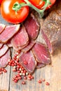 Slices of cured meet on wooden table vertical Royalty Free Stock Photo