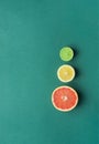 Slices of Cut in Half Organic Citrus Fruits Grapefruit Lemon Lime on Dark Green Background. Imitation of Stop Lights. Superfoods