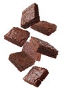 Slices of delicious chocolate brownie flying on white background