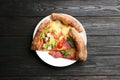 Slices of different delicious pizzas on black table, top view