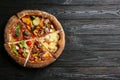 Slices of different delicious pizzas on black wooden table, top view. Space for text Royalty Free Stock Photo