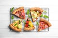 Slices of different delicious pizzas on white wooden table, flat lay Royalty Free Stock Photo