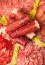 Slices of different kinds of meat with green salad. Toned