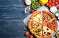 Slices of different pizzas on wooden table, flat lay. Space for text Royalty Free Stock Photo