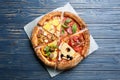 Slices of different pizzas on blue wooden table, top view Royalty Free Stock Photo