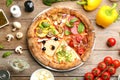 Slices of different pizzas on wooden table, flat lay