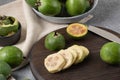 Slices and different sized pieces of chopped feijoa on dark backboard. Vitamin juice preparation