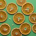 Slices of dried oranges arranged on a solid green background Royalty Free Stock Photo