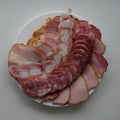 Slices Of Fat Pork Sausage, Smoked Ham And Bacon Ribs On White Surface Top View Square Photo Royalty Free Stock Photo