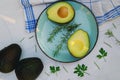 Slices of fresh avocado with herbs and lemons lies on the table on a blue plate. Flat lay. Top view. Healthy food concept. Diet Royalty Free Stock Photo