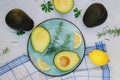 Slices of fresh avocado with herbs and lemons lies on the table on a blue plate. Flat lay. Top view. Healthy food concept. Diet Royalty Free Stock Photo