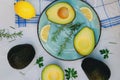 Slices of fresh avocado with herbs and lemons lies on the table on a blue plate. Flat lay. Top view. Healthy food concept. Diet Royalty Free Stock Photo