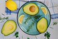 Slices of fresh avocado with herbs and lemons lies on the table on a blue plate. Flat lay. Top view. Healthy food concept. Diet Royalty Free Stock Photo