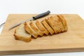 Slices of fresh bread and a cutting knife on a wooden board. White background, isolated