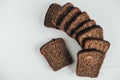 Slices of fresh brown bread with raisins on a white wooden background. Top view. Copy, empty space for text Royalty Free Stock Photo